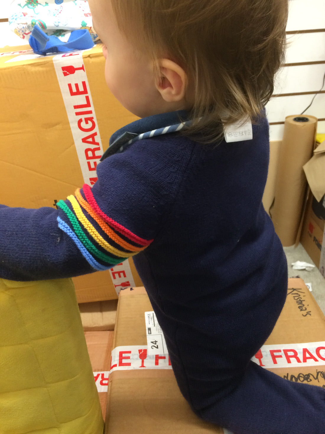 Boy climbing on boxes with fragile tape on them