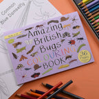 Coloring book titled 'Amazing British Bugs' with colored pencils on a wooden surface