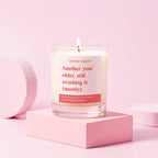 Candle in clear glass jar with label saying another year older, still crushing it (mostly)