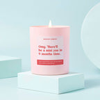 Pink glass jar candle with a message 'OMG there'll be a mini you in 9 months time' in red writing