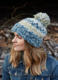 Totnes bobble beanie in a green and blue mix, with a bobble on the top