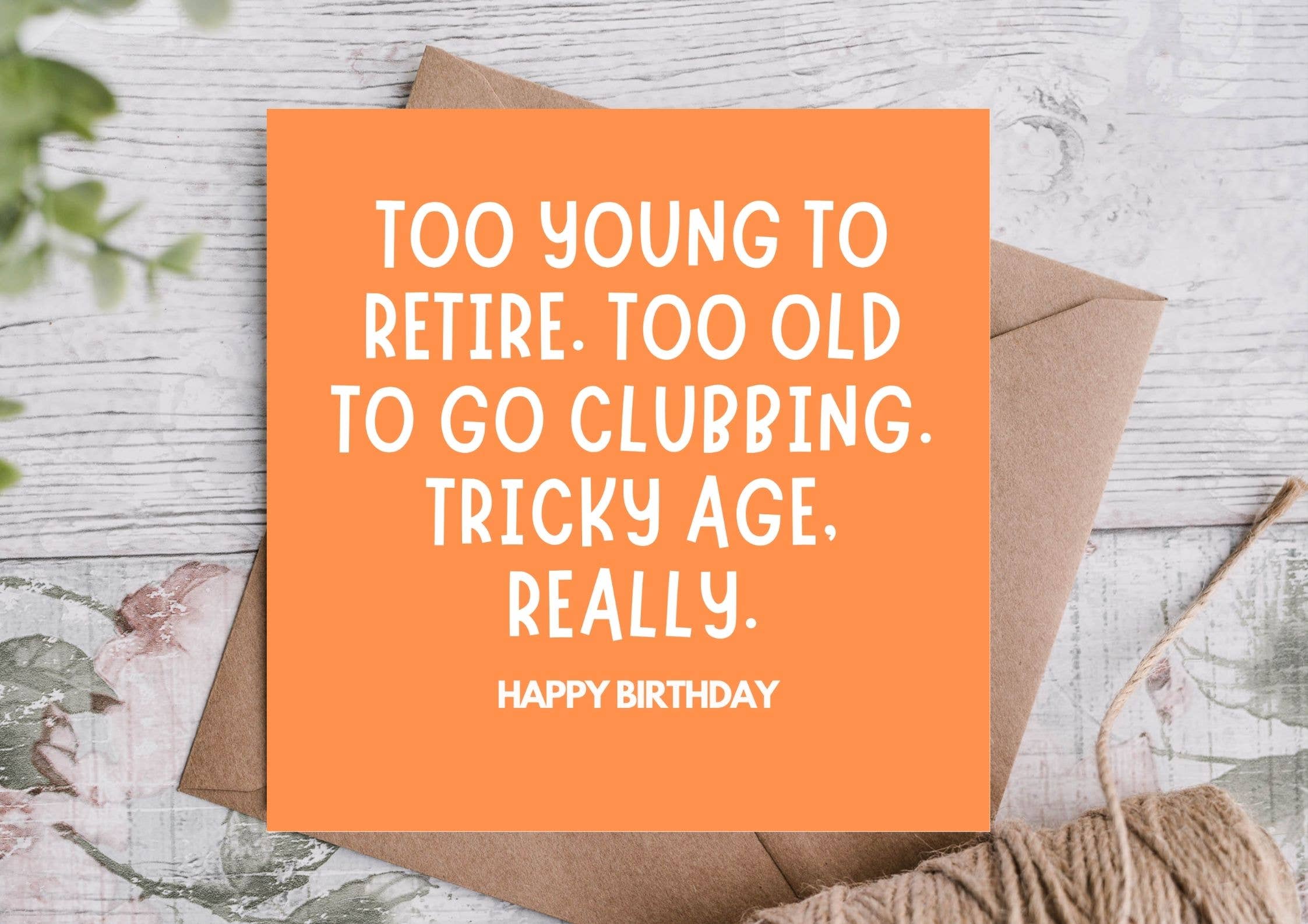 Orange birthday card with humorous text on a wooden surface