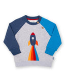 Grey jumper with a rocket on the front, sleeves are two different blues.