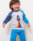 Grey jumper with a rocket on the front, sleeves are two different blues.